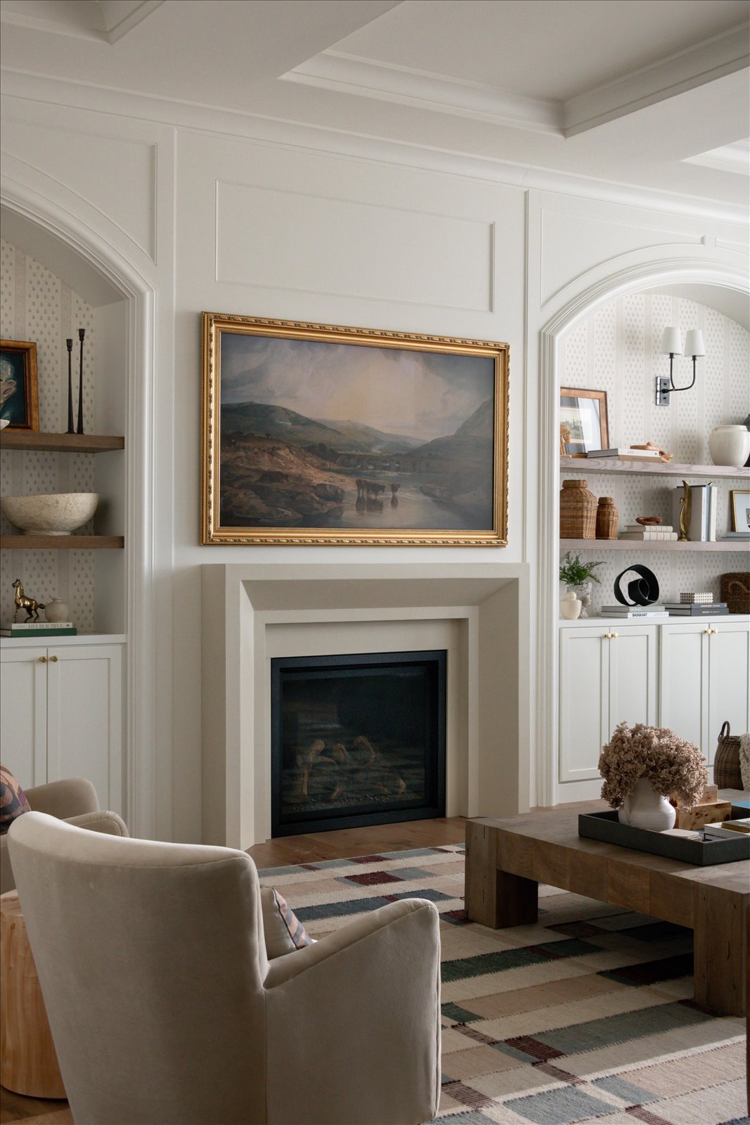 Elegantly styled living room featuring an Oltre cast stone fireplace surround installed above a firebox, photographed by Kristine Kohl