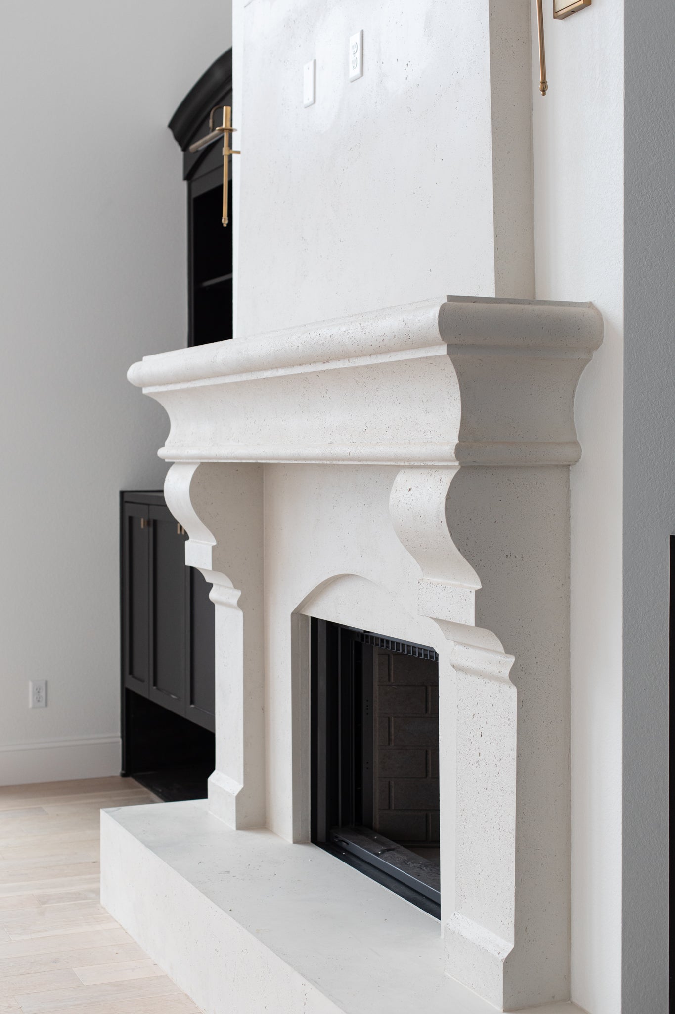 Petite Tuscan cast limestone fireplace surround installed at the Pickette residence