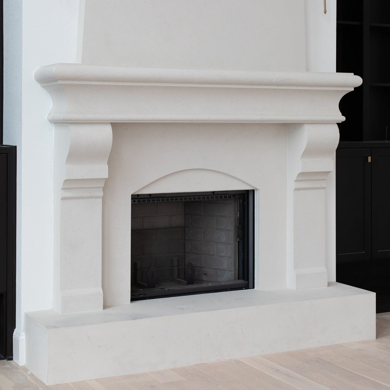 Petite Tuscan cast limestone fireplace surround installed at the Pickette residence