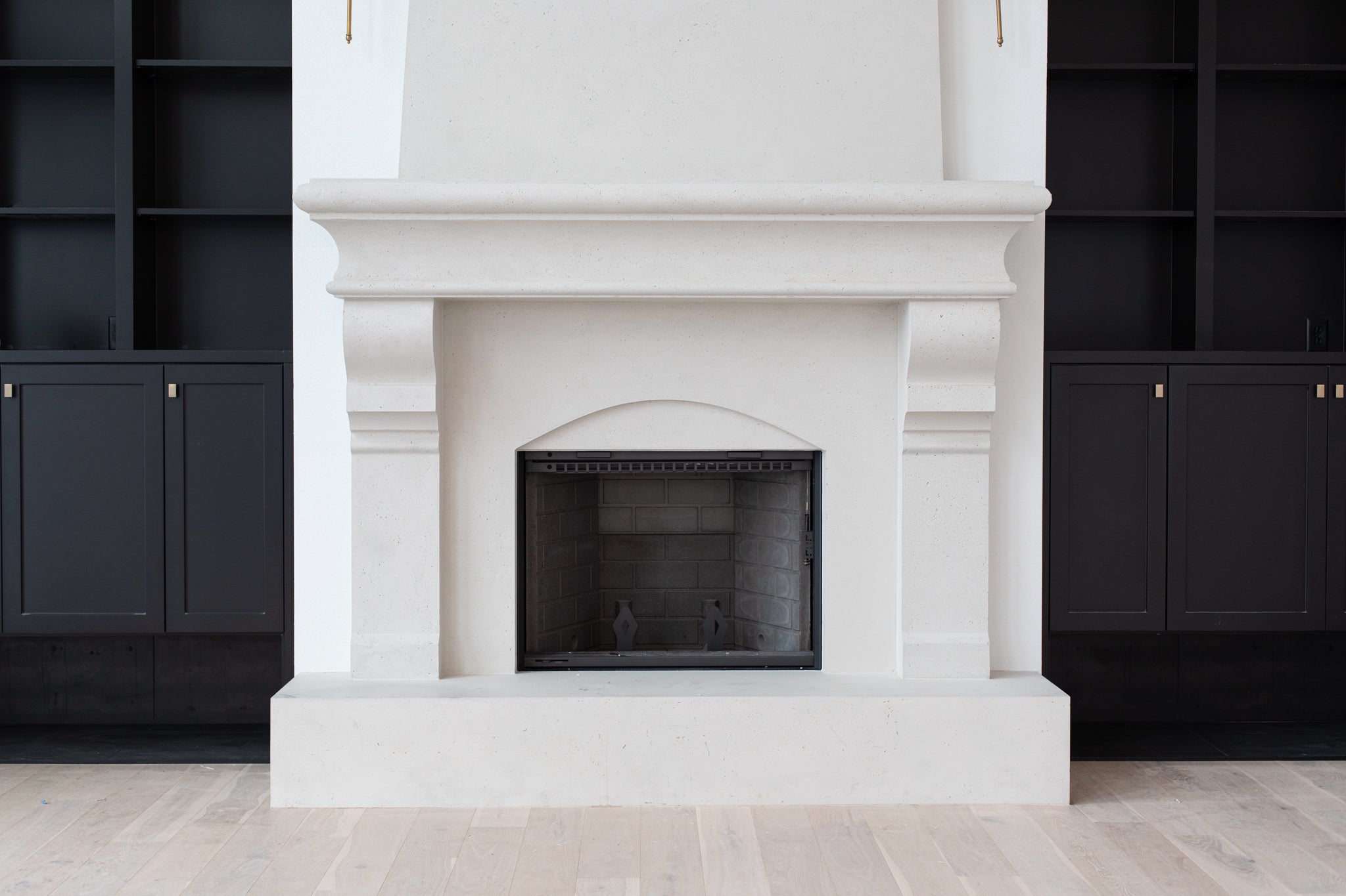 Petite Tuscan cast limestone fireplace surround installed at the Pickette residence